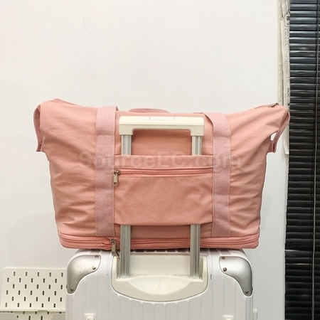 Expandable wheeled travel bag with retractable handle